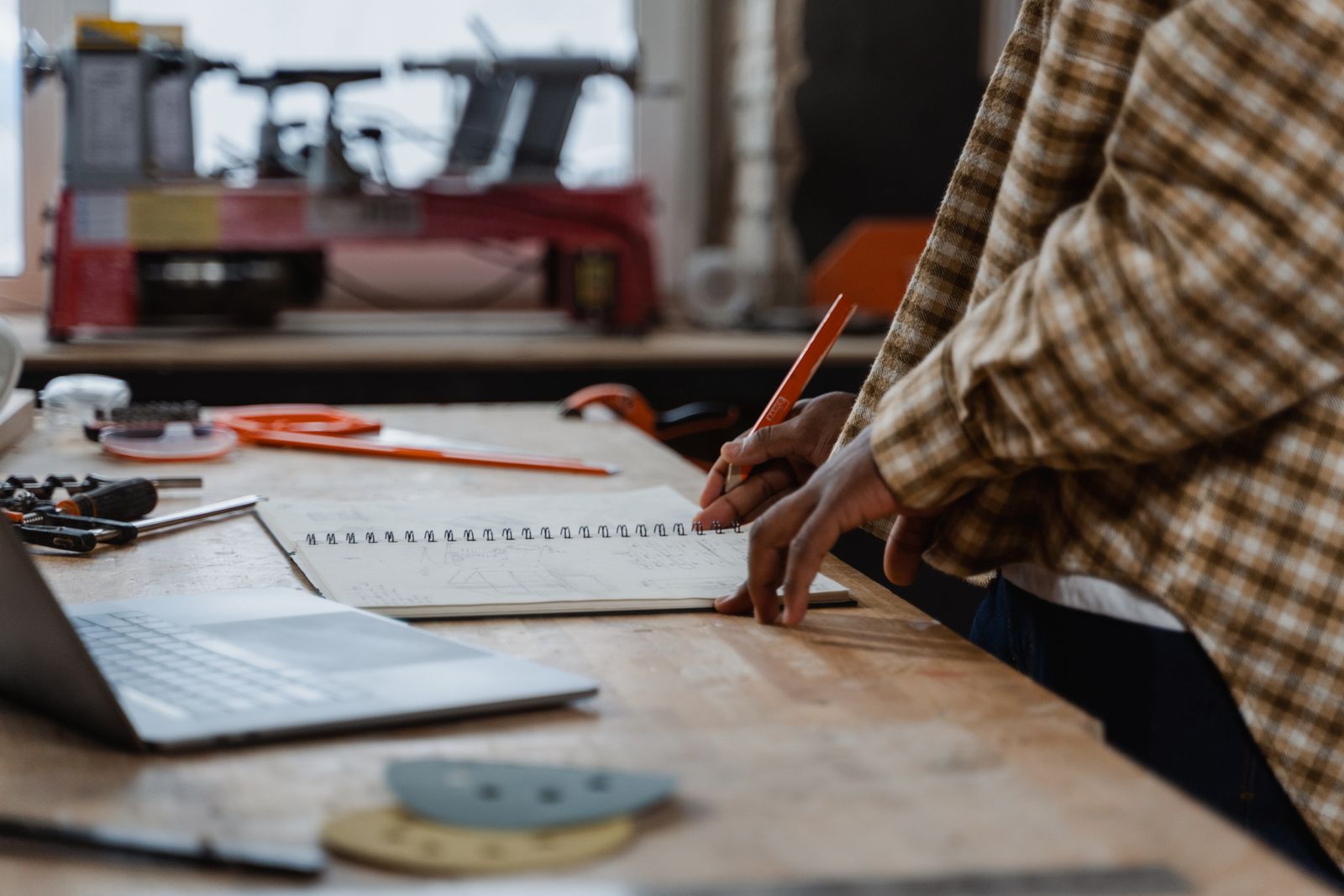 An independent maker planning their next project at a workbench